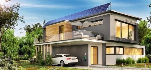 electric car being charged outside home with solar panels on roof