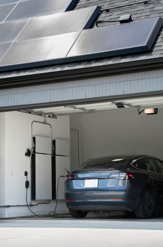 solar panels on roof powering an electric car charger in garage